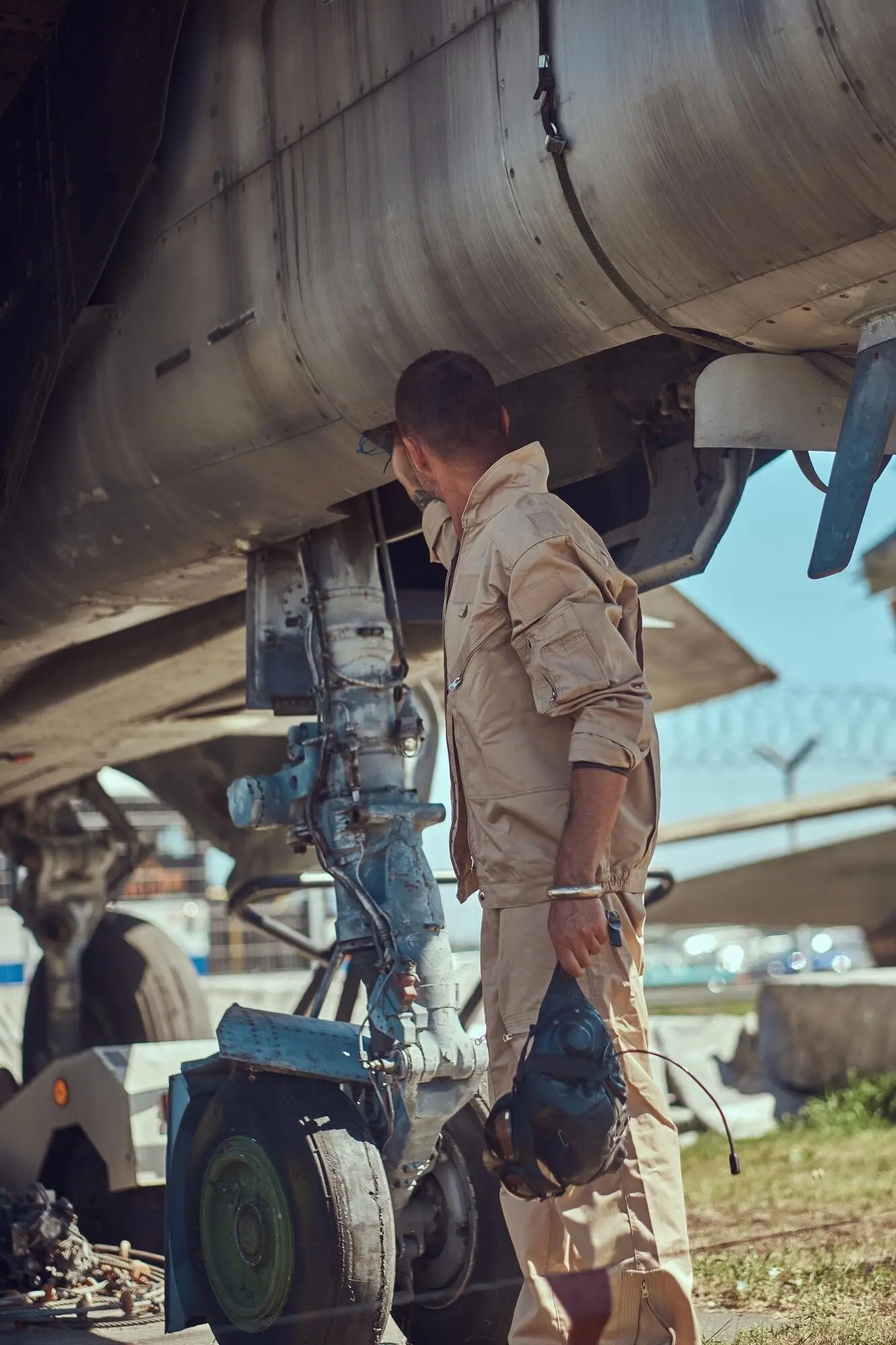 野外博物館で、制服姿の整備士が軍用の迎撃戦闘機の近くに立っている。